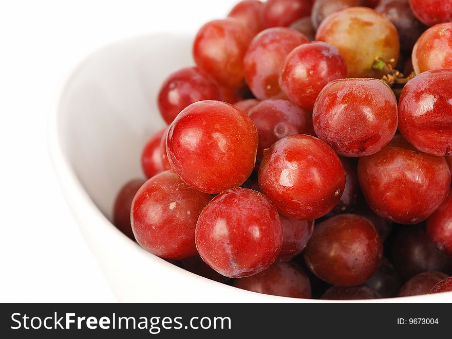 Red grapes in  big china bowl closeup isolated on the white background. Red grapes in  big china bowl closeup isolated on the white background.