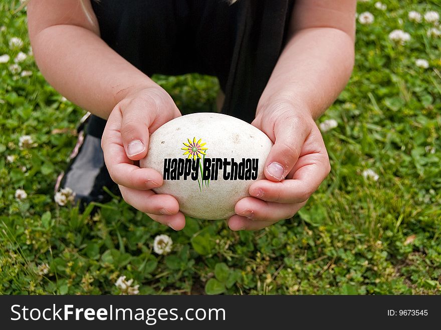 Little girl holding a goose egg with birthday message. Little girl holding a goose egg with birthday message.