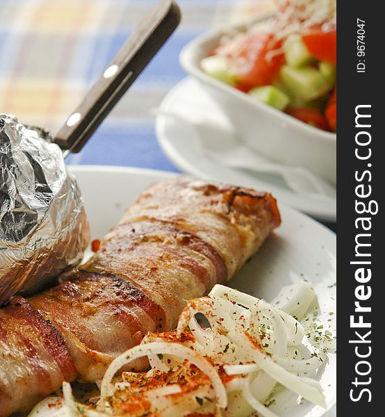 Grilled meat served with potato and salad. Grilled meat served with potato and salad