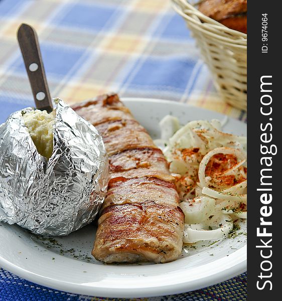 Grilled meat served with potato and onion. Grilled meat served with potato and onion