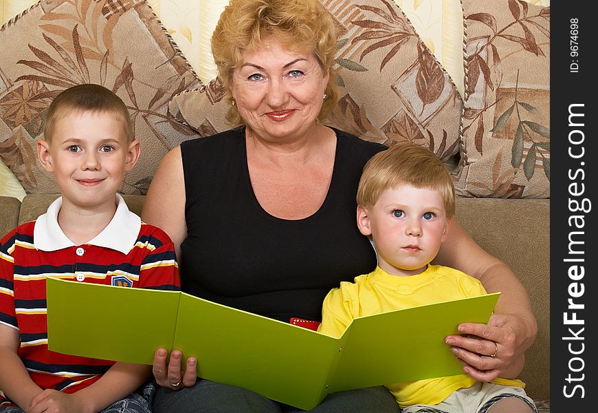 Young grandmother with two grandchildren at home on the couch. Young grandmother with two grandchildren at home on the couch