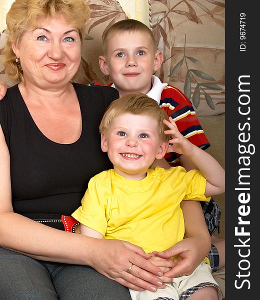 Young grandmother with two grandchildren at home on the couch. Young grandmother with two grandchildren at home on the couch