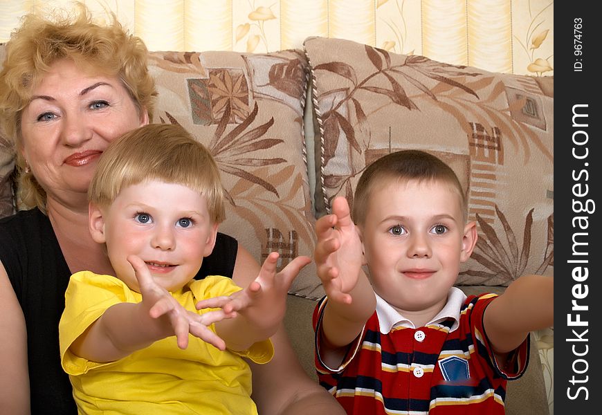 Young grandmother with two grandchildren at home on the couch. Young grandmother with two grandchildren at home on the couch