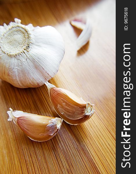 Garlic bulb and its slices on wooden texture