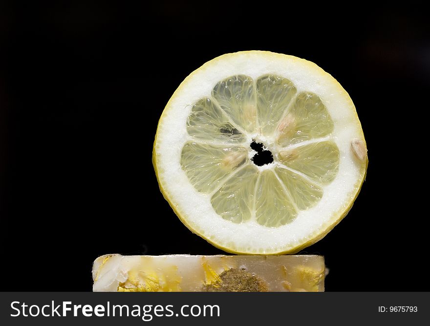 Photo of a lemon slice on a black background. Photo of a lemon slice on a black background