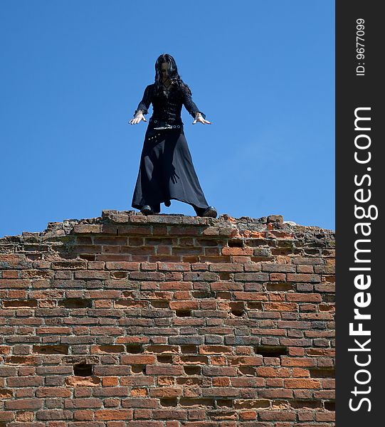 Young gothic girl and ruins of castle