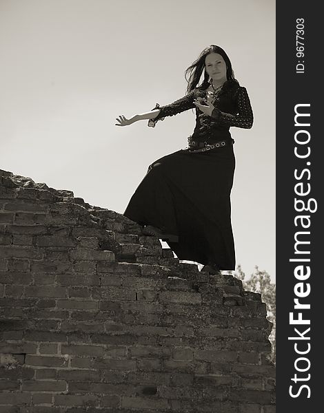 Young gothic girl and ruins of castle