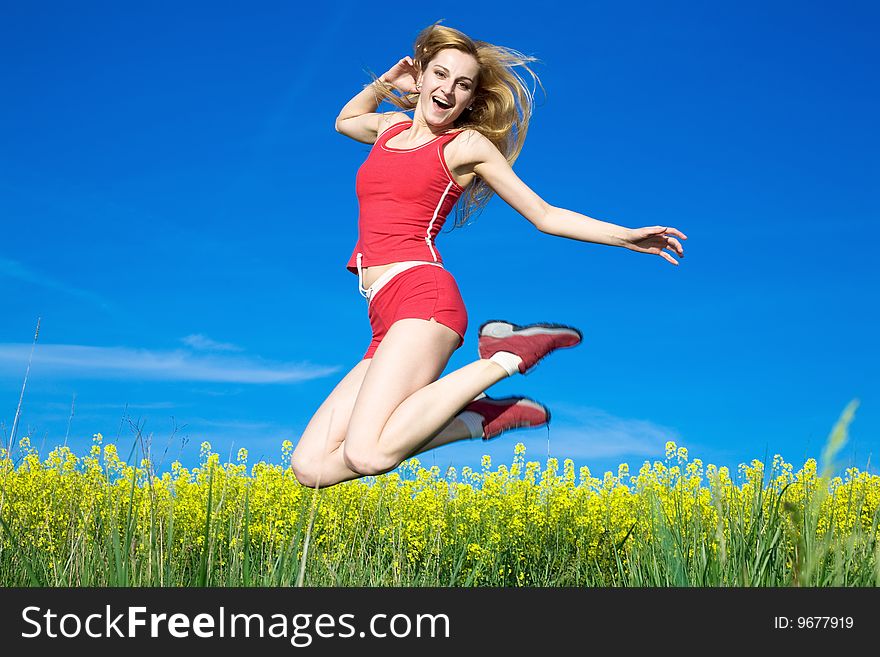 A beautiful  girl jumping on a background of blue sky. A beautiful  girl jumping on a background of blue sky