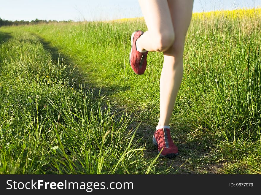 An image of woman's feet running on the road