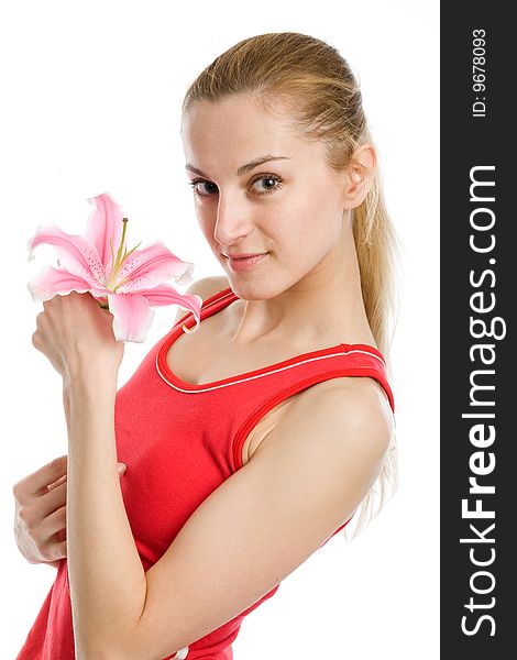 A nice blond girl in red posing with a pink lily near her face on a white background. A nice blond girl in red posing with a pink lily near her face on a white background