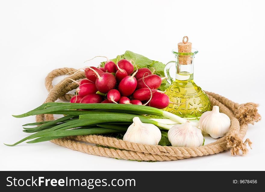 A rope ring and olive oil with greens in the middle of it. A rope ring and olive oil with greens in the middle of it