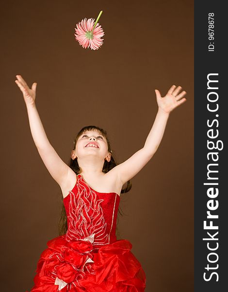 A beautiful child in a red dress with a flower