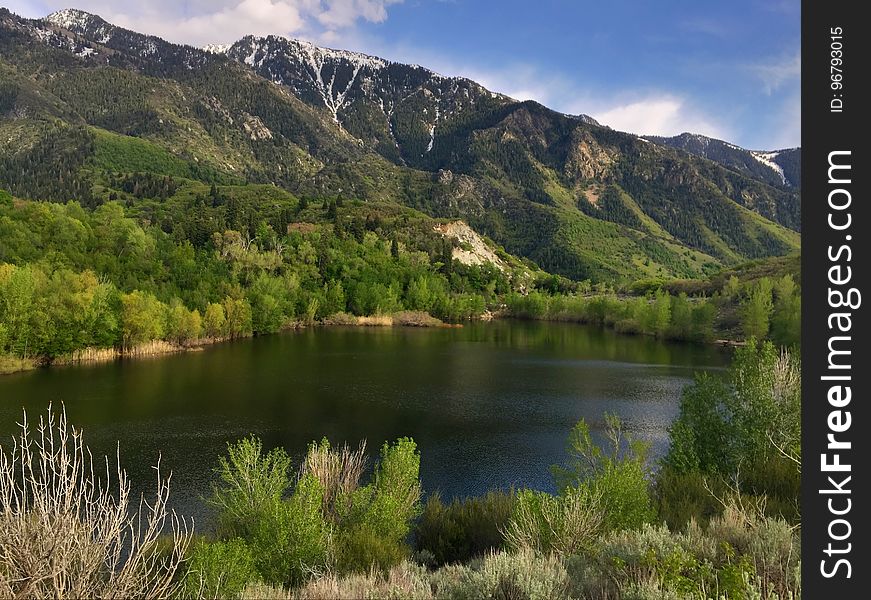 A view of a mountain lake and mountain slopes in the background.