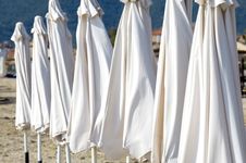 Closed White Parasols On Beach Royalty Free Stock Images