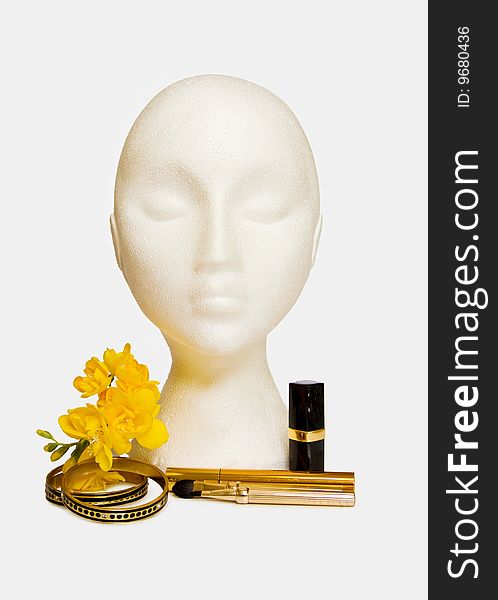 Items of beauty and luxury - mannequin with makeups, lipstick, mascara, golden jewellery and yellow freesia. Items of beauty and luxury - mannequin with makeups, lipstick, mascara, golden jewellery and yellow freesia.