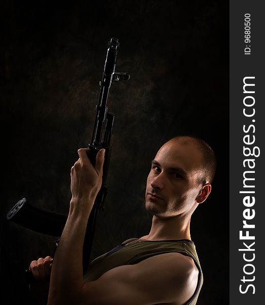 Man with the Kalashnikov gun. Low-key portrait.