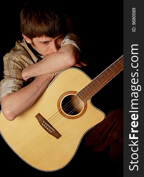 Young musician playing guitar isolated on black. Young musician playing guitar isolated on black