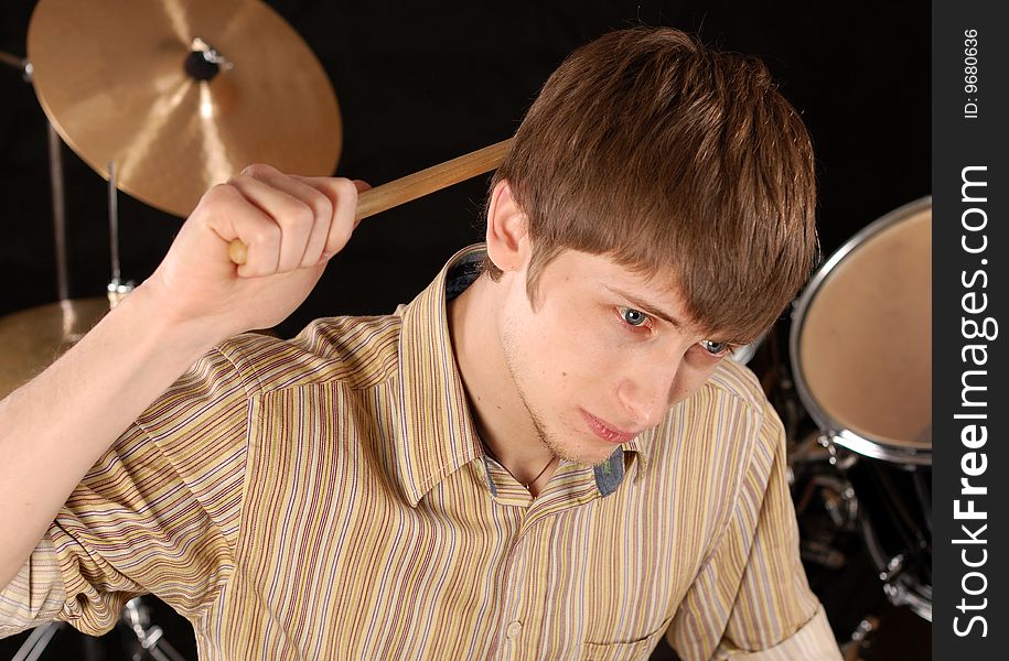 Young musician playing drums isolated on black. Young musician playing drums isolated on black.