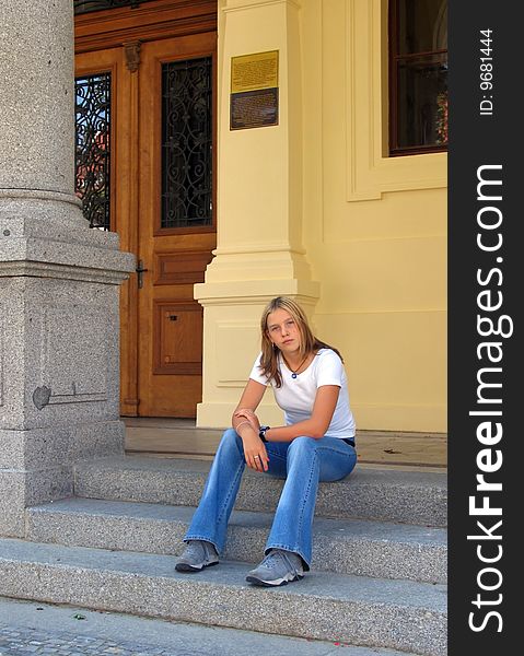Teen girl sitting on the stairs.