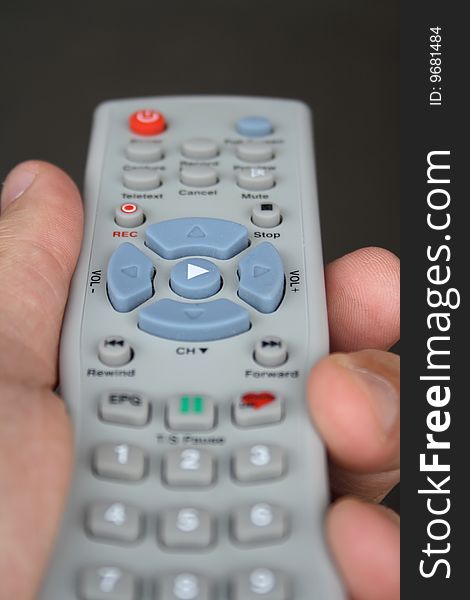 A hand holding a TV remote. A hand holding a TV remote