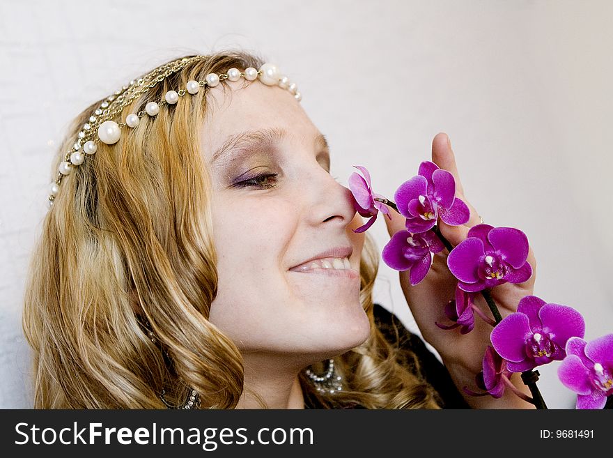 Lovely Blond girl with orchid on grey background