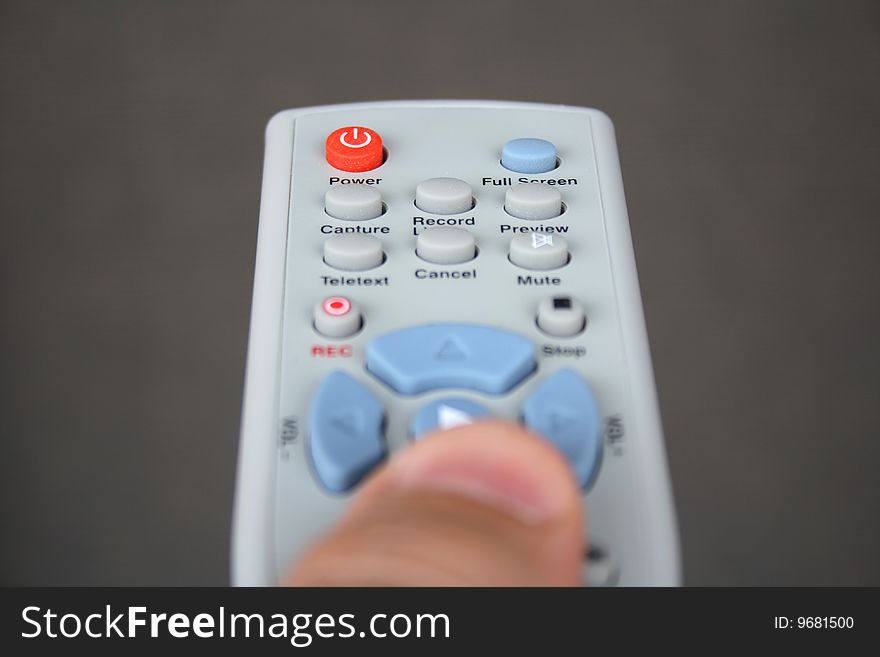 A hand holding a TV remote. A hand holding a TV remote