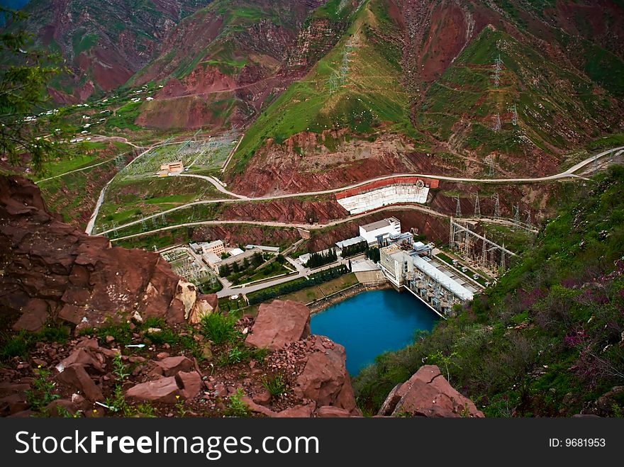 Water basin with blue water in red mountains The top view on Hydroelectric power station. Water basin with blue water in red mountains The top view on Hydroelectric power station.