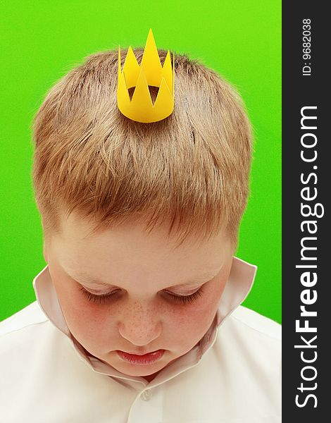 Boy with a crown on a green background