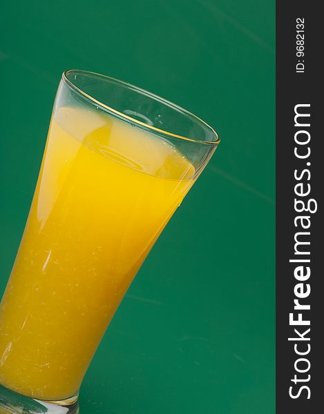 Glass of orange juice on green  background. Glass of orange juice on green  background