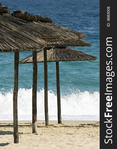 Straw umbrellas on the empty beach. Straw umbrellas on the empty beach