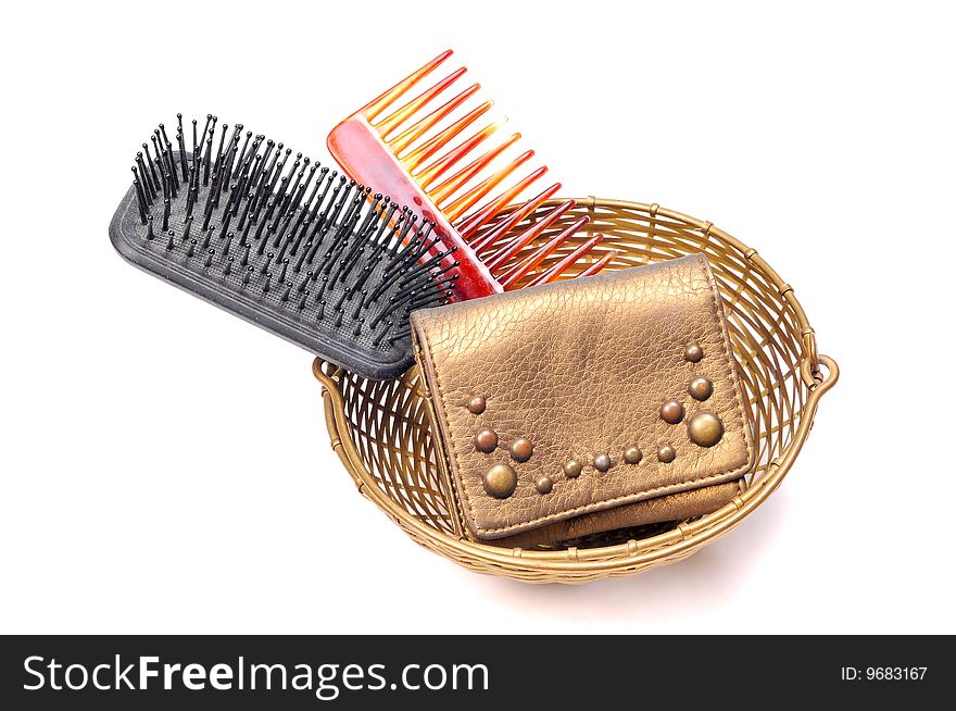 Brush, comb and leather purse in basket.