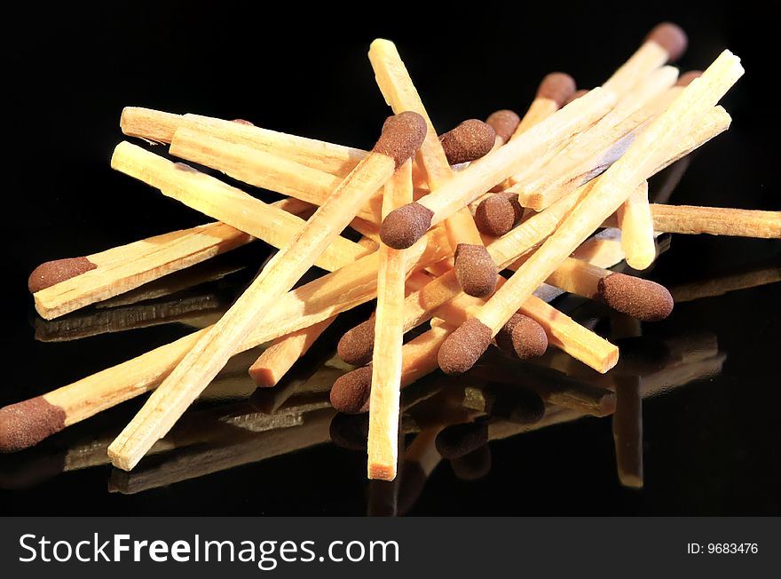 Bunch of matches isolated on a black reflective surface. Bunch of matches isolated on a black reflective surface