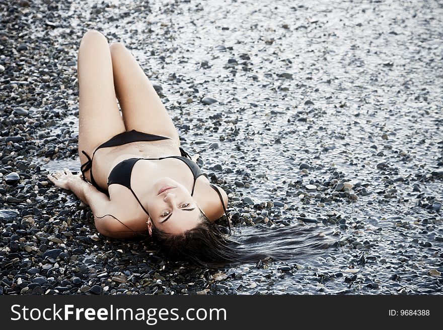 Laying green eyed beauty wearing black small bikini. Laying green eyed beauty wearing black small bikini.