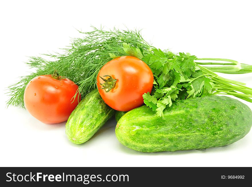 Cucumbers, tomatoes and greens on a white background