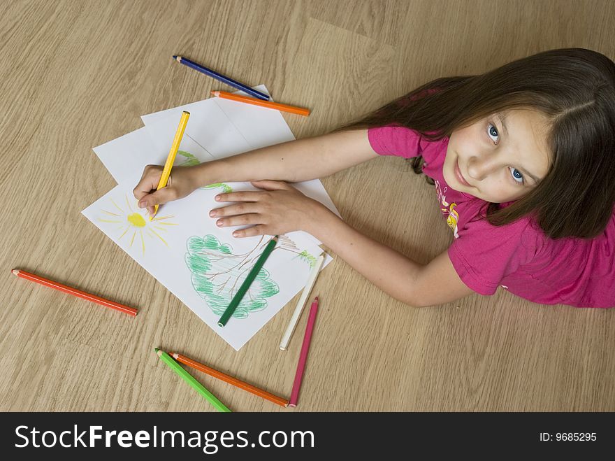 Young girl lying on the floor and drawing a picture. Young girl lying on the floor and drawing a picture