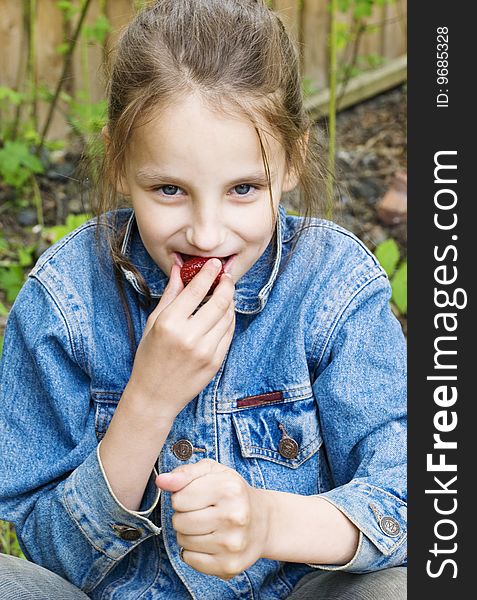 Girl eating fresh strawberry at picnic. Girl eating fresh strawberry at picnic