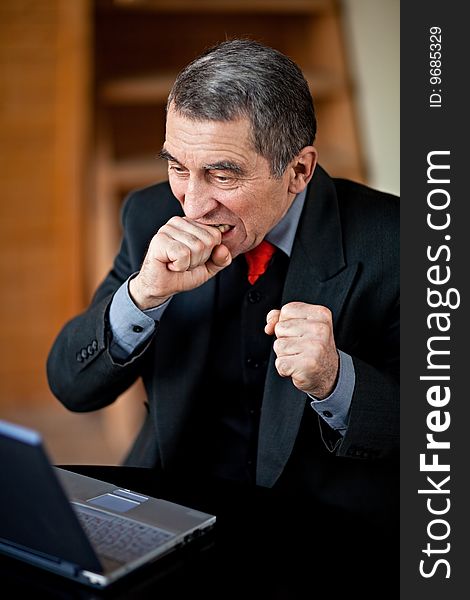 A businessman recoils from his laptop computer in horror. A businessman recoils from his laptop computer in horror.