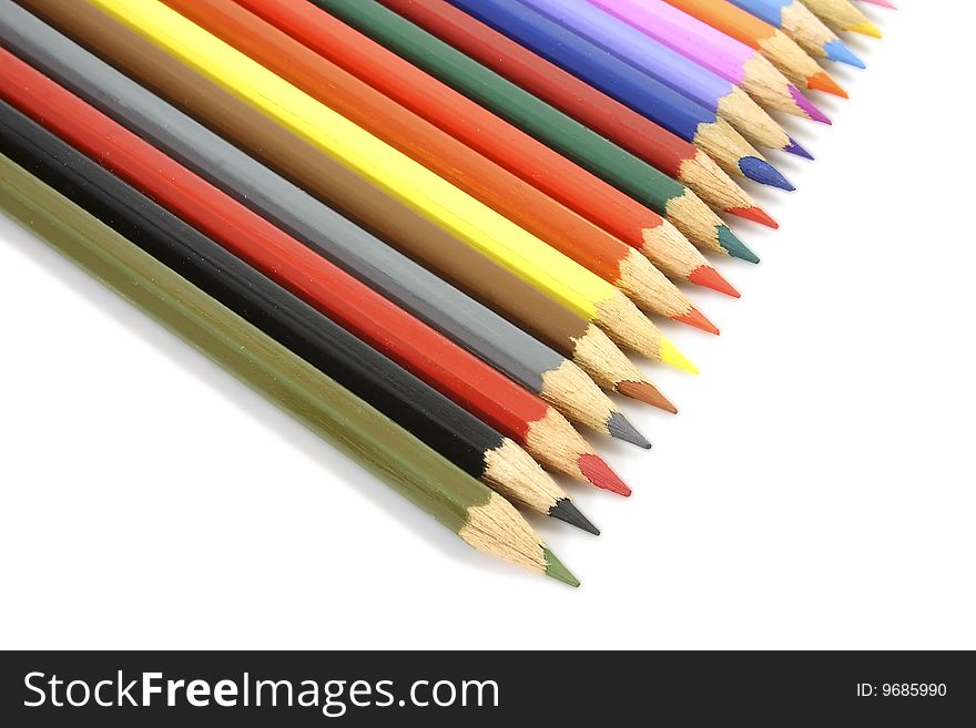 Set of colour pencils, for the drawing, spread out one after another, on the isolated white background
