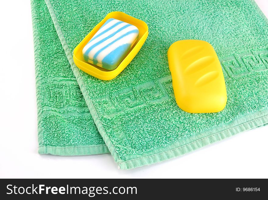 Green towel and soap on a white background