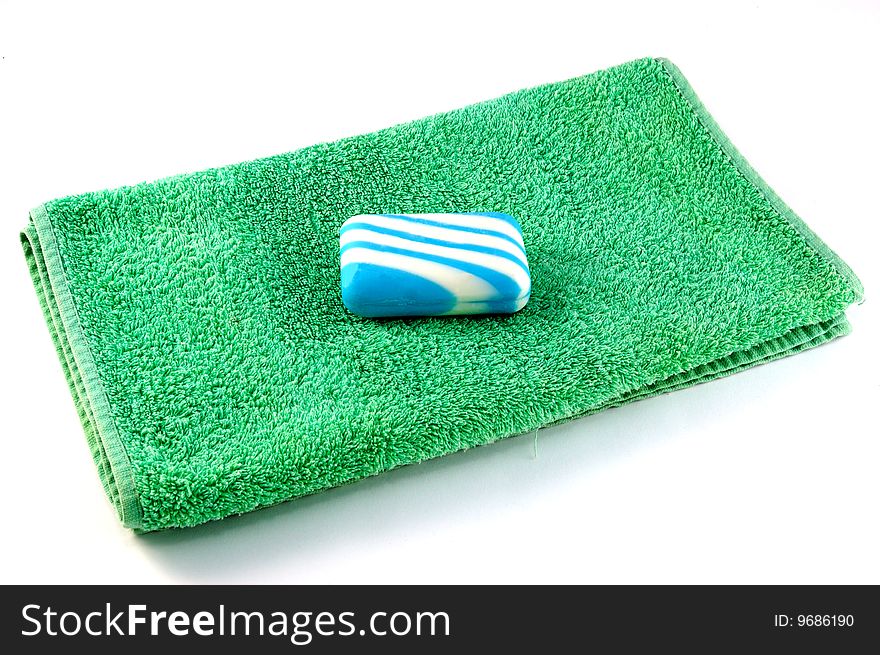 Green towel and soap on a white background