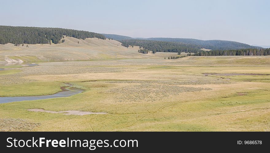 Yellowstone prairie valleys with river meandering through it and animal tracks observable. Yellowstone prairie valleys with river meandering through it and animal tracks observable