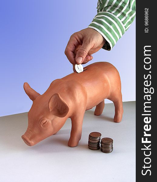 Hand Dropping Coin In Piggy Bank