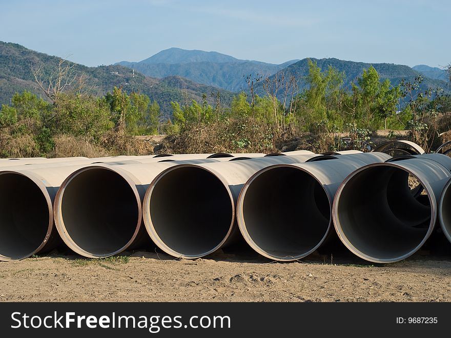 Rows of drainge sewage pipes with mountain background. Rows of drainge sewage pipes with mountain background