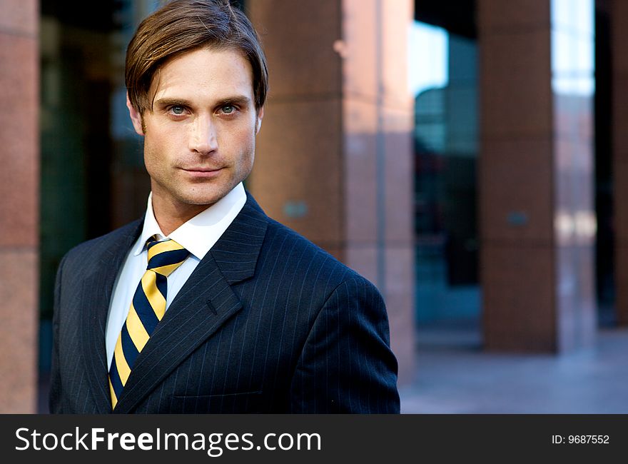 Attractive Businessman in front of a modern office building. Attractive Businessman in front of a modern office building