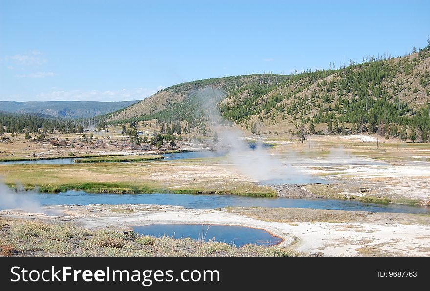 Yellowstone landscape with undulating river and steaming hot springs. Yellowstone landscape with undulating river and steaming hot springs