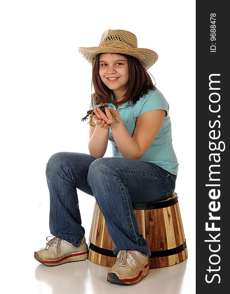 A preteen farm girl happy with the spotted green frog she holds.  Isolated on white. A preteen farm girl happy with the spotted green frog she holds.  Isolated on white.