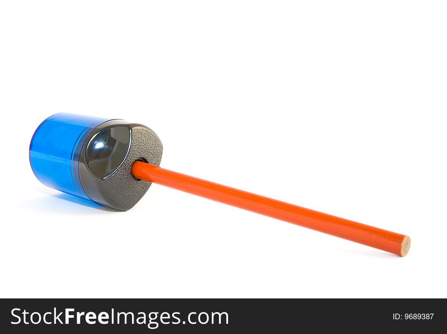 Orange pencil in a blue and black sharpener on a white background. Orange pencil in a blue and black sharpener on a white background