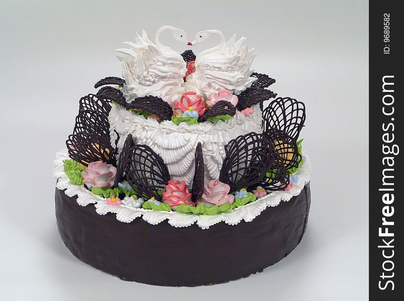 Chocolate beautiful multi-tiered tier wedding cake with white glaze, and swans. Chocolate beautiful multi-tiered tier wedding cake with white glaze, and swans