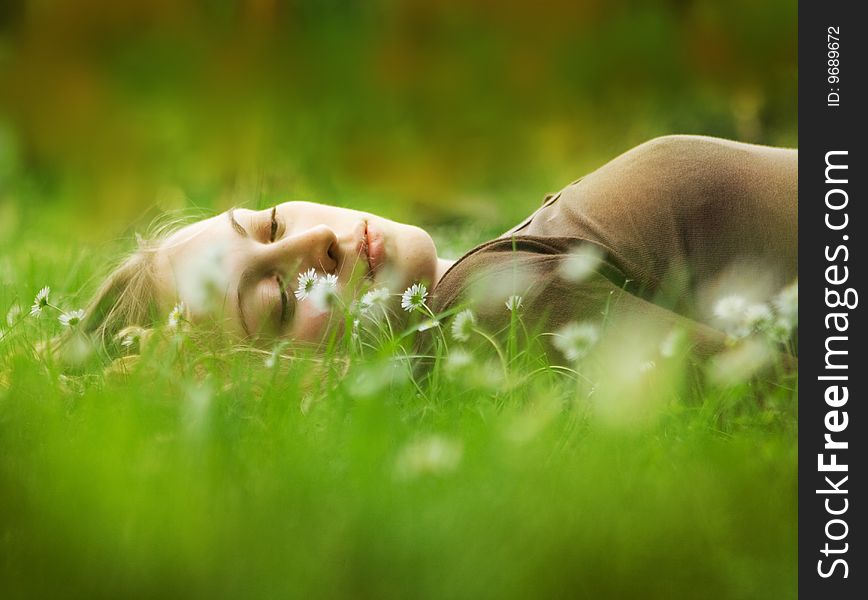happy woman lying in grass on a meadow full of daisies. happy woman lying in grass on a meadow full of daisies