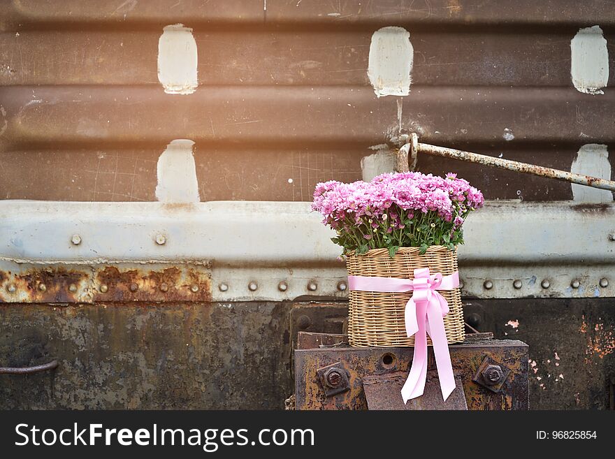 Lovely pink chrysanthemum flowers in the bamboo basket on the rusted steel background for love.